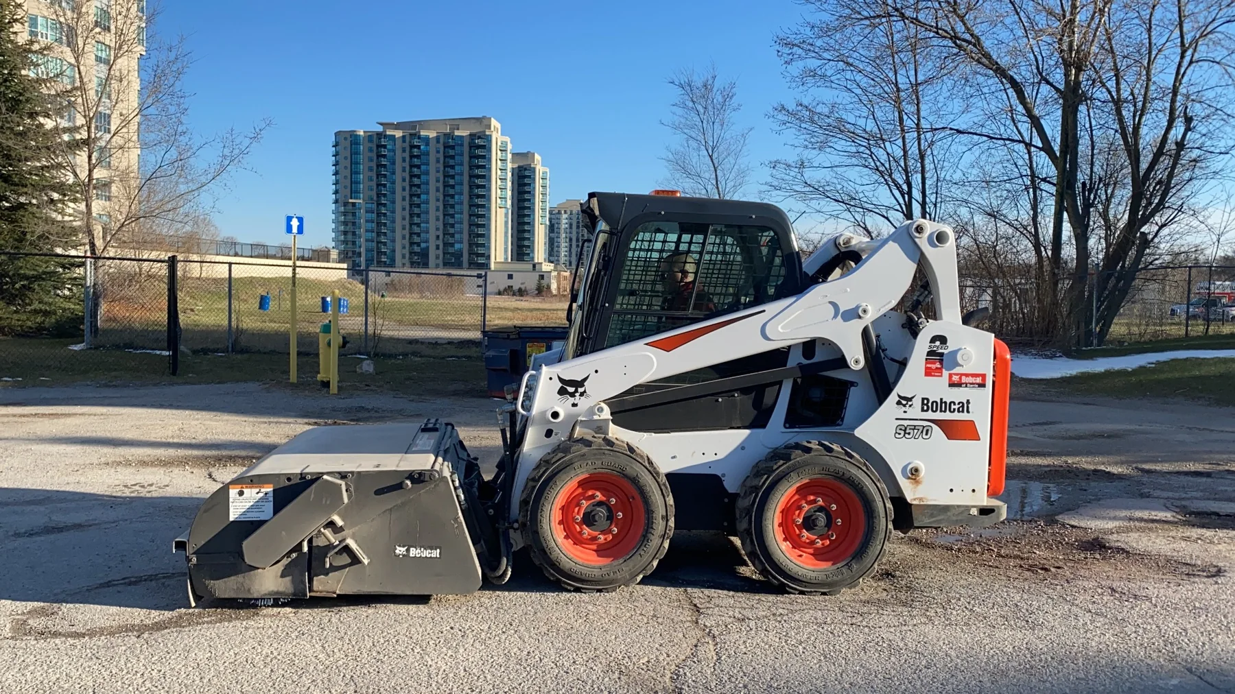 Bobcat skid steer with parking lot power sweeper attachment used by Stratton's