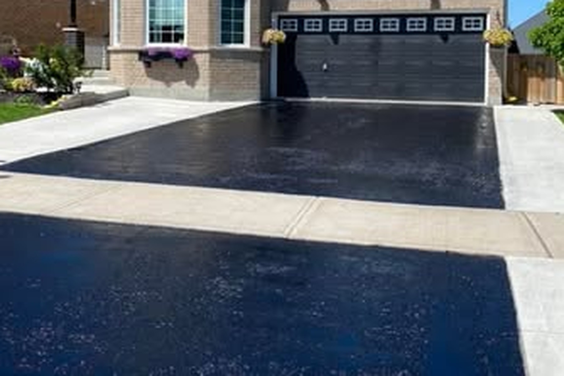 Close view of the clean black finish on a sealed asphalt driveway
